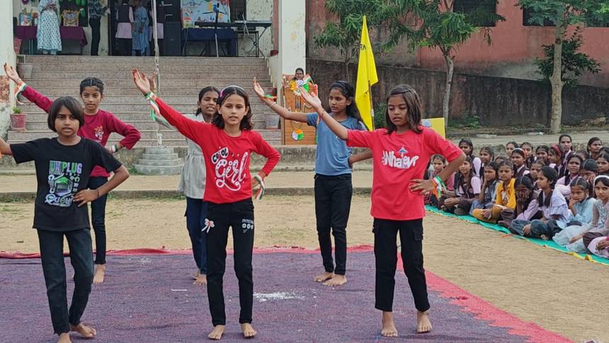 Students performing a group dance on stage before the school audience