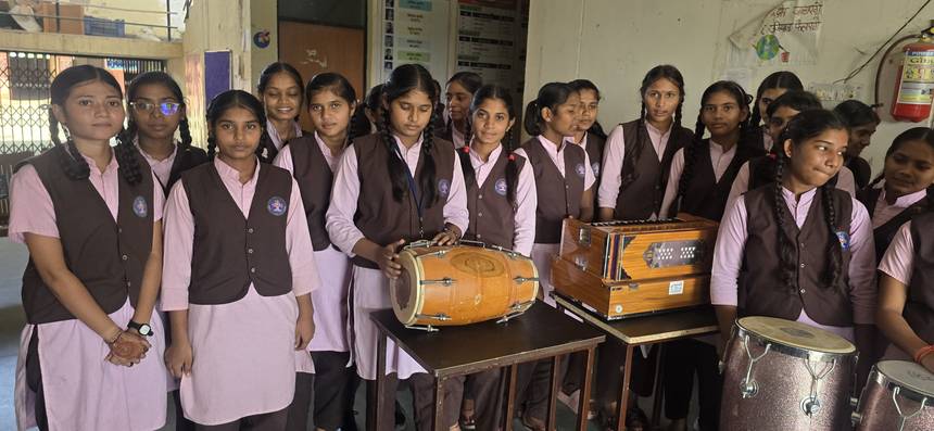 Students with the harmonium, dholak and tabla in the school music room