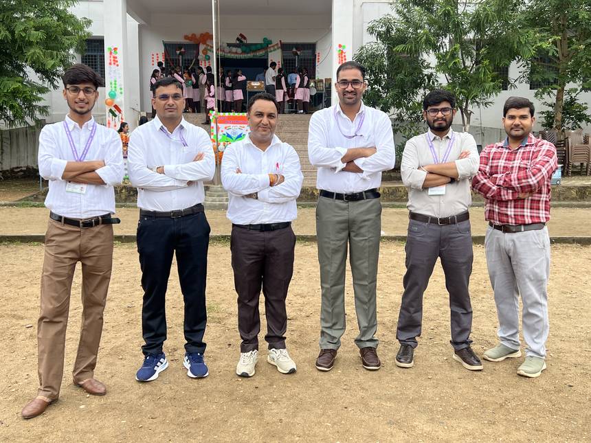 Staff outside the school entrance decorated in tricolour for a national day programme