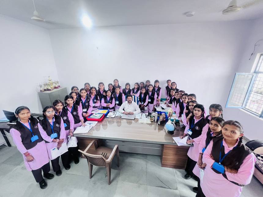 Students at the school office desk with trophies displayed in the cabinet behind