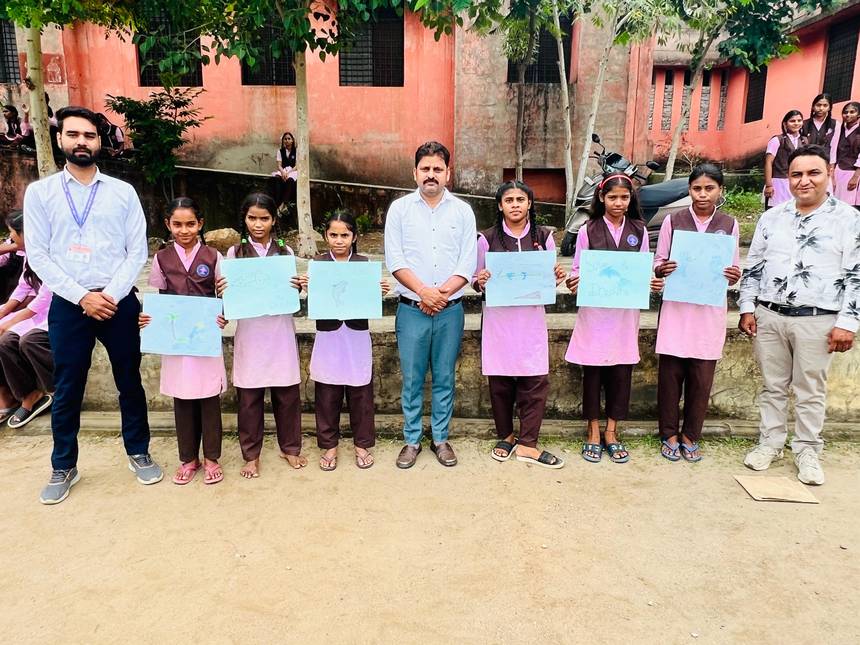 Students holding up their drawing sheets outside the school building