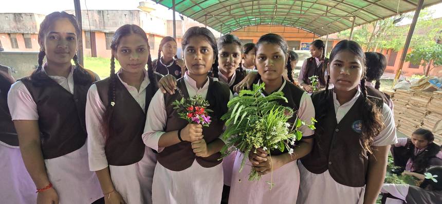 Students holding plants and flowers during a campus plantation activity