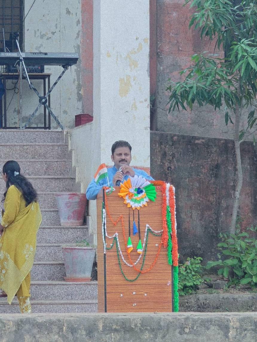 A speaker addressing the school from a decorated podium at a campus event