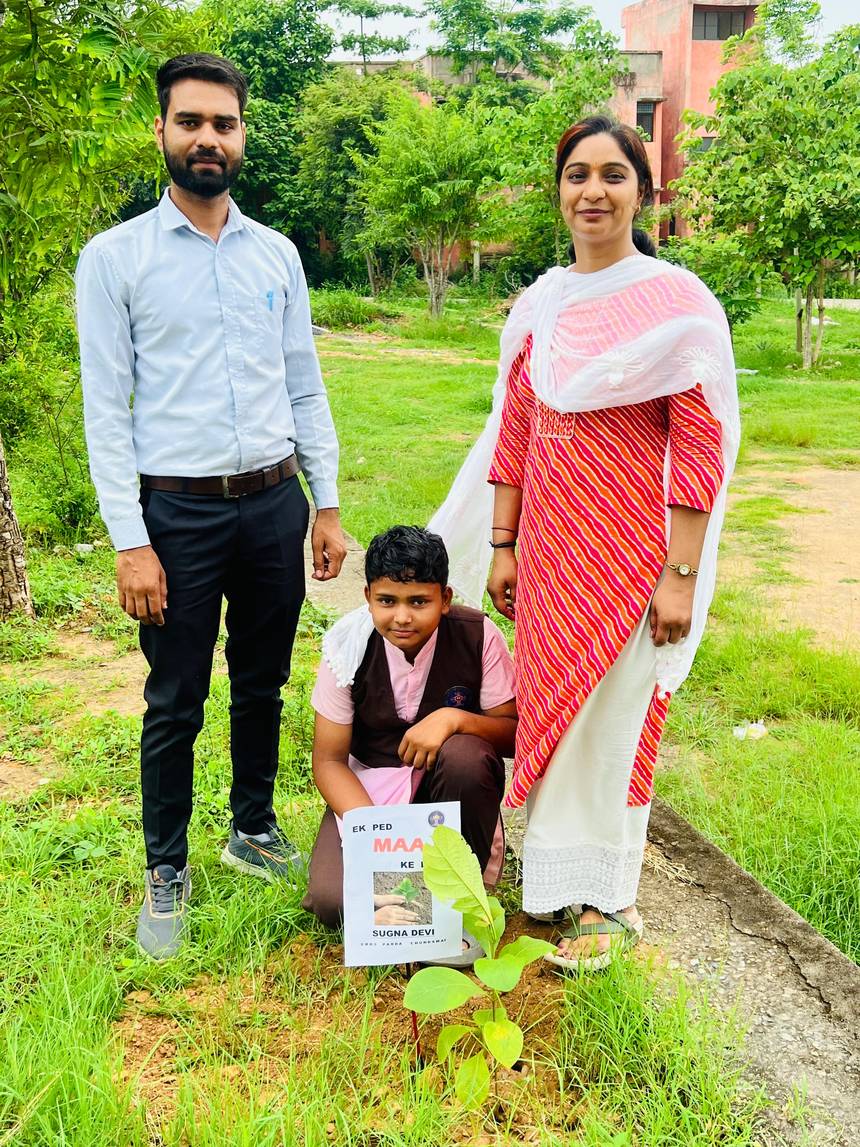A student and teachers with a newly planted sapling on the school campus