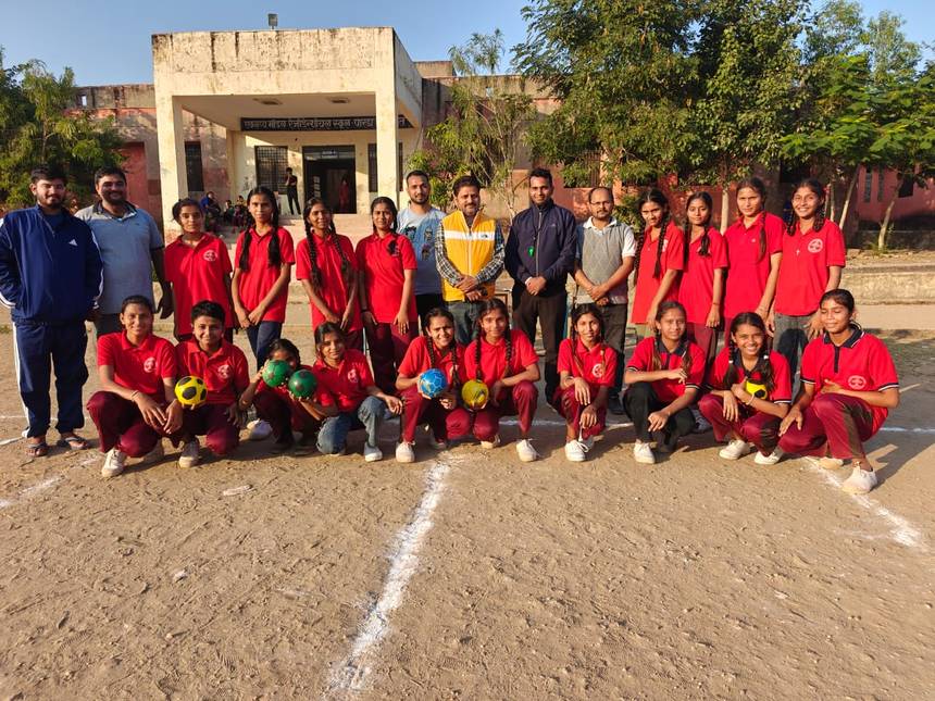 School sports team in red jerseys with coaches on the campus playground
