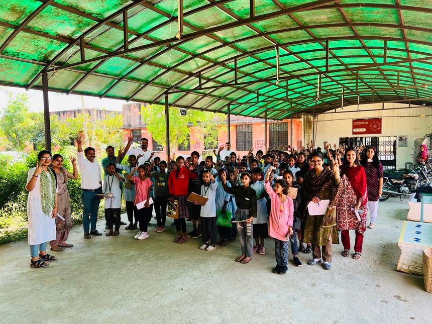 Staff and students gathered together under the covered area on campus