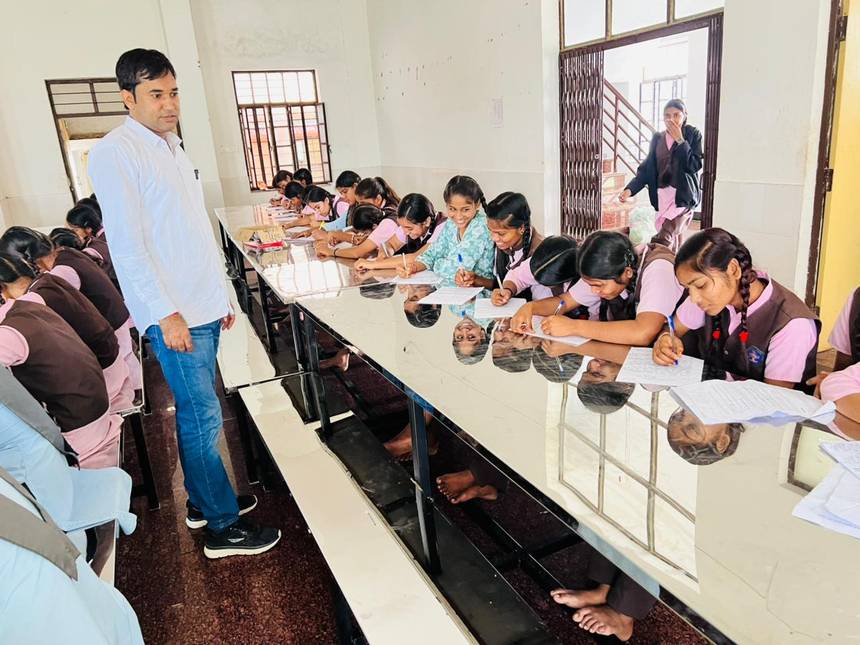 A teacher supervising students during a written activity in school